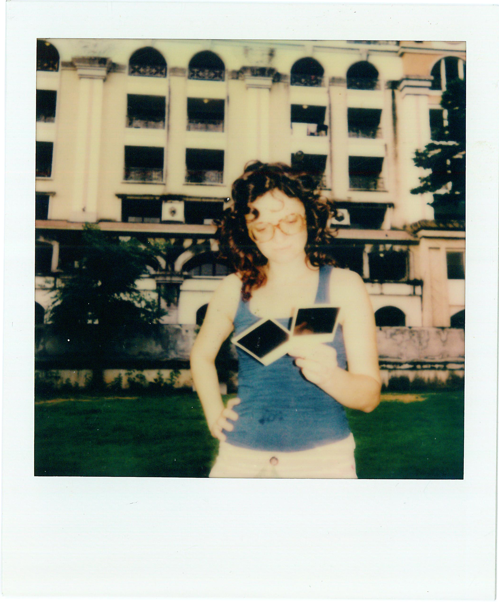 EN: Francesca Svampa holding Polaroid photographs, photographed on Polaroid film. ES: Francesca Svampa sosteniendo fotografías Polaroid, retratada en película Polaroid.
