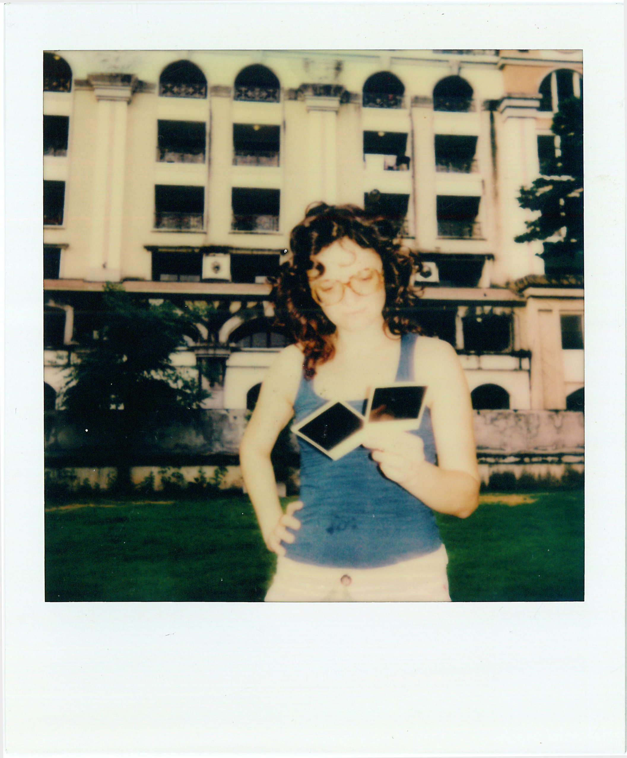 EN: Francesca Svampa holding Polaroid photographs, photographed on Polaroid film. ES: Francesca Svampa sosteniendo fotografías Polaroid, retratada en película Polaroid.